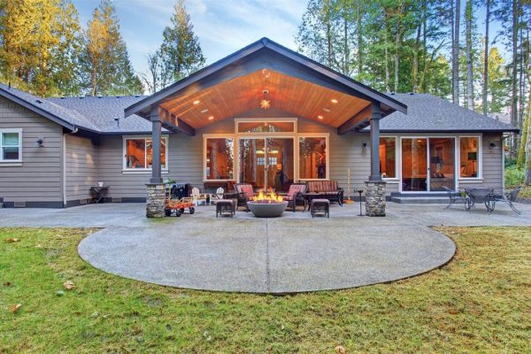 A serene outdoor space with a covered patio surrounded by lush greenery.